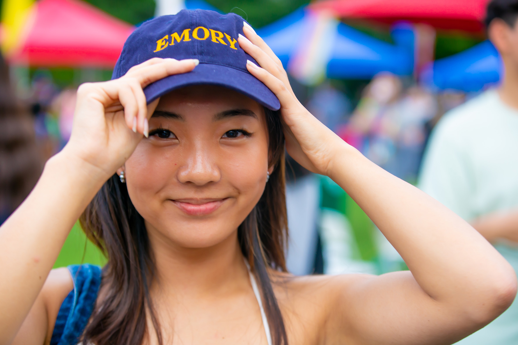 Student posing with Emory hat