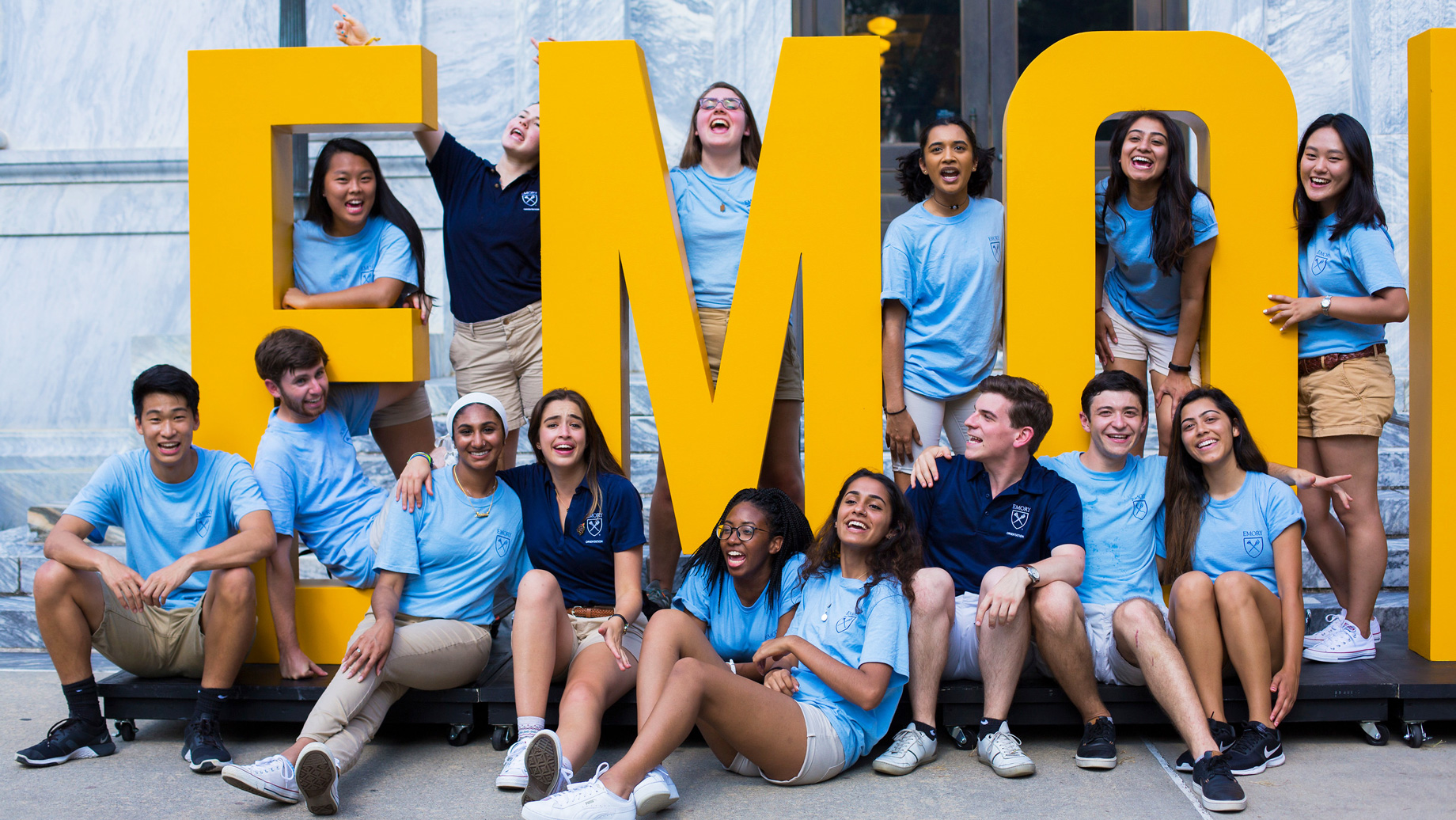 students gather around huge EMORY letters