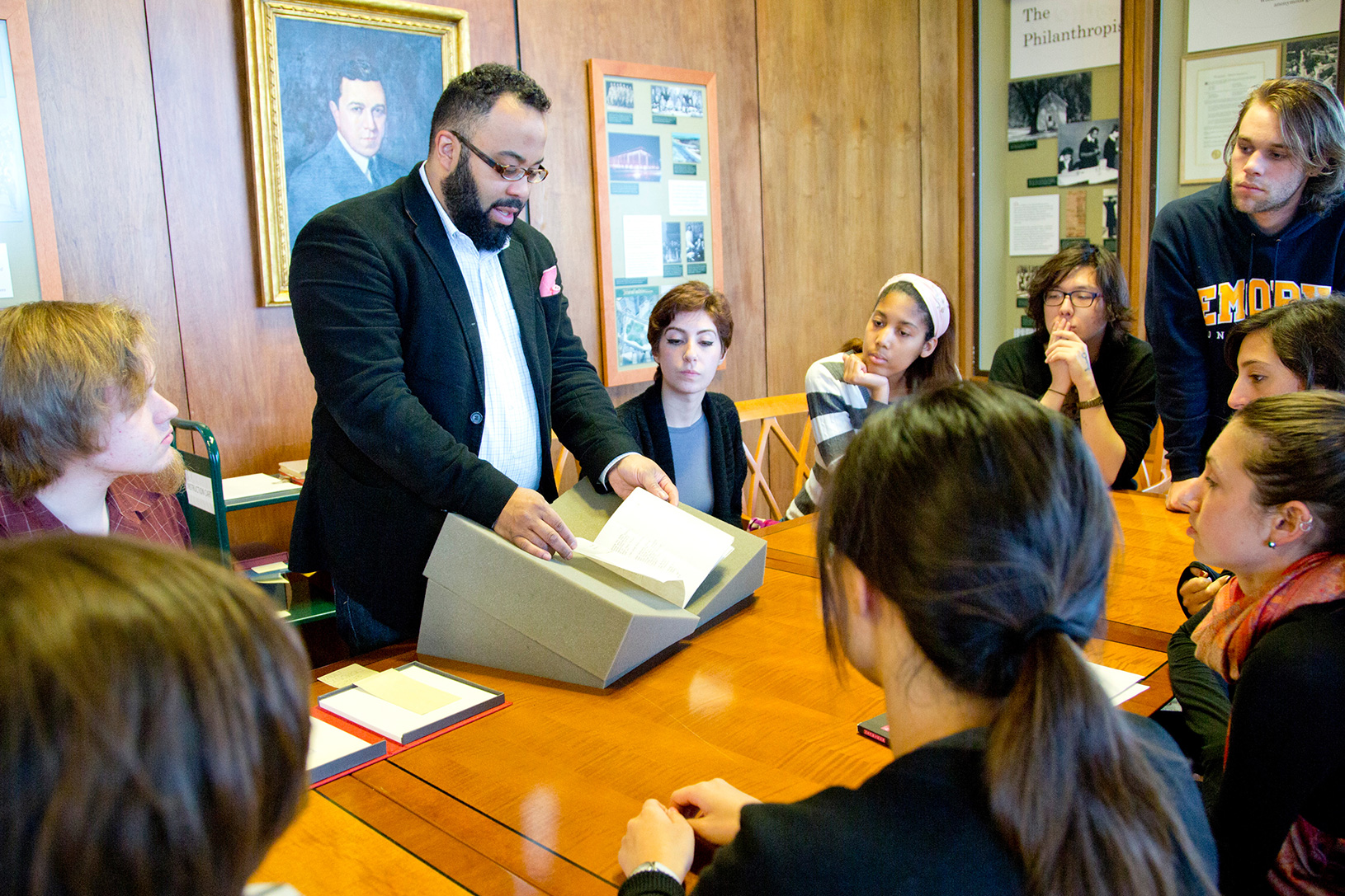 professor shows rare book to students